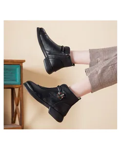 Detailed side view of black fleece-lined winter boots with a decorative flower and side zipper