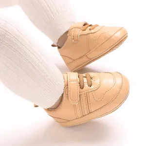 Dettaglio ravvicinato di scarpe da ginnastica beige per neonati con suole morbide