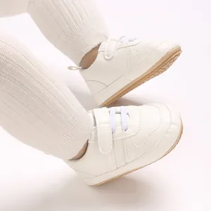 Dettaglio di scarpe primi passi bianche per neonati con chiusura a strappo e texture