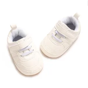 Primo piano di scarpe bianche per neonati con chiusura a strappo e lacci elastici