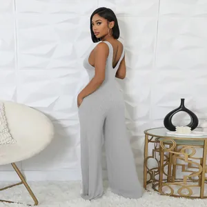 Model trägt einen grauen, hochelastischen, gerippten, ärmellosen Jumpsuit mit weitem Bein
