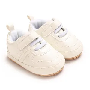 Dettaglio di scarpe primi passi per neonati bianco crema con suola morbida e velcro