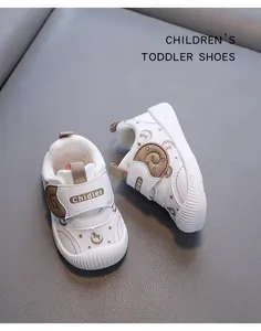 Detailed close-up of white breathable mesh toddler shoes featuring soft soles and bear accents