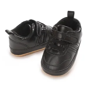 Primo piano di scarpine primi passi nere per neonati con suola morbida e velcro.