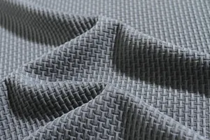Close-up detail of gray seersucker fabric texture for men's athletic short sleeve shirt.