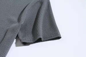 Macro detail of grey men's short-sleeve athletic shirt showing textured seersucker fabric