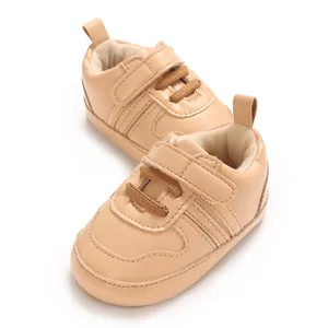 Primo piano di scarpe primi passi beige per neonati con suola morbida e chiusura a strappo