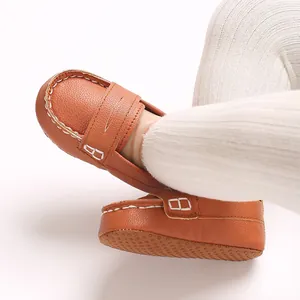 Detail of soft brown faux leather infant loafers featuring non-slip rubber dotted soles