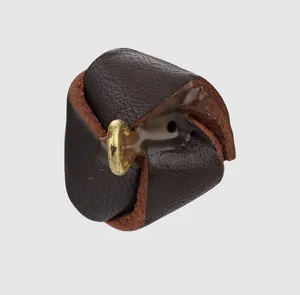 Détail macro d'un bouton décoratif en cuir de vachette marron foncé pour vêtements