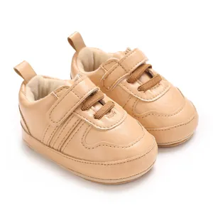 Dettaglio macro di scarpine primi passi beige con velcro e suola morbida per neonati.
