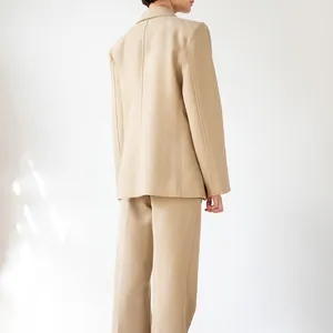 Elegant beige two-piece suit set with structured blazer and matching trousers.