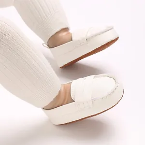 Detailed close-up of white soft-sole infant loafers with non-slip texture detail