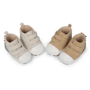 Zapatos altos para bebés con suelas blandas y correas de velcro en colores beige y marrón.