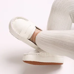 Close-up of white soft-soled anti-slip infant leather loafers with textured surface
