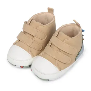 Detalle de zapatos para bebé con acentos de dinosaurio y cierres de velcro