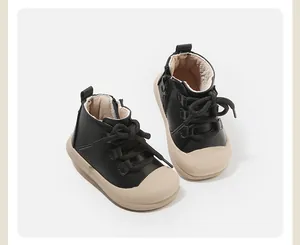 Detailansicht schwarzer Kleinkind-Lauflernschuhe mit beigen Sohlen und Reißverschluss