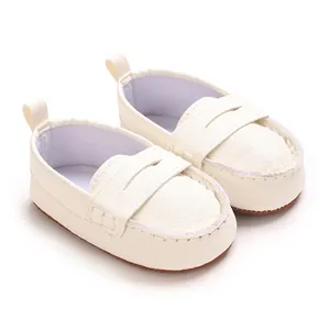 Close-up of white soft-sole baby loafers with textured faux leather finish