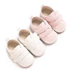 Detaillierte Nahaufnahme von weichen Baumwoll-Babyschuhen in Rosa und Weiß für Kleinkinder