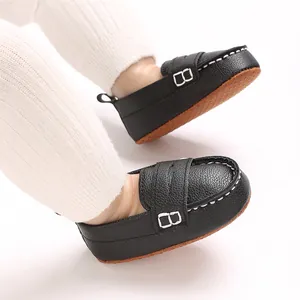 Close-up detail of black faux leather baby loafers with a soft anti-slip rubber sole