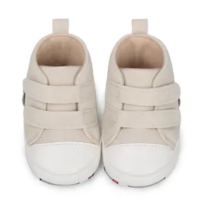 Detalle de zapatos beige para caminar para bebés con suelas blandas y velcro.
