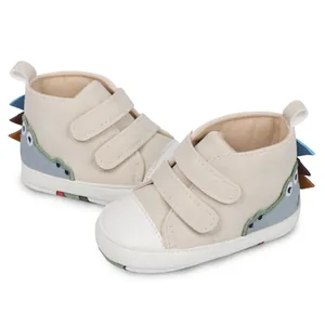 Vista detallada de zapatos altos para bebé con patrón de dinosaurio y cierre de velcro