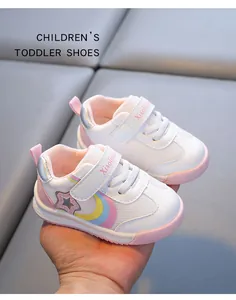 Detailed view of white toddler walking shoes with rainbow accents and soft pink sole