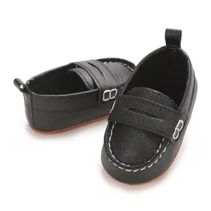 Detailed view of black baby leather loafers featuring soft soles and white stitching