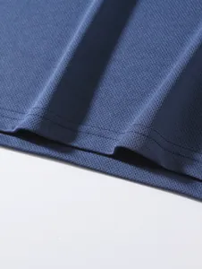 Nahaufnahme von atmungsaktivem blauem Netzgewebe und Nähten an einem Sport-Unterhemd.