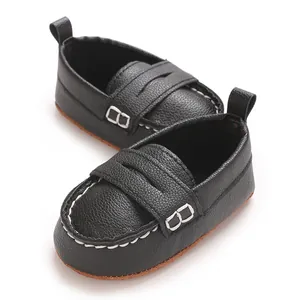 Detailed view of black baby loafers with soft non-slip soles and white stitching