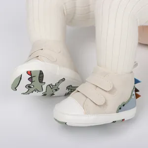 Primer plano de zapatos de bebé con un lindo diseño de dinosaurio y suela blanda