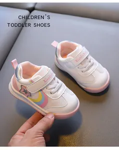 Close-up of white breathable toddler shoes featuring rainbow motifs and pink accents