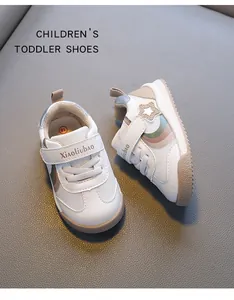 Close-up of breathable white toddler walking shoes with rainbow stripes and velcro strap.