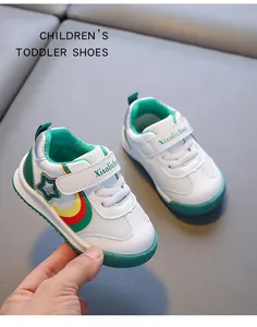 Close-up of white breathable toddler shoes with green accents and velcro strap