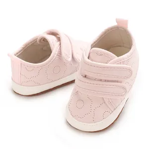 Nahaufnahme rosa Baby-Lauflernschuhe mit Klettverschluss und weißer Gummisohle