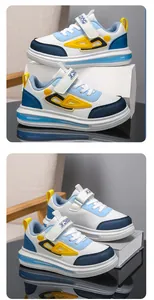 Detailed side view of stylish blue and white boy's sneakers with yellow accents.