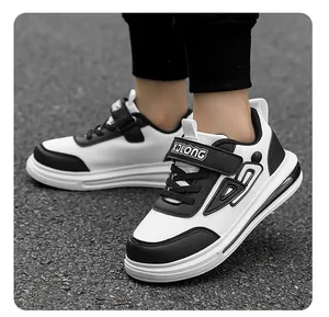 Detailed side view of boys' black and white leather casual sneakers with Velcro strap