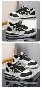 Detailed macro view of black and white boys' sneakers featuring secure velcro straps.