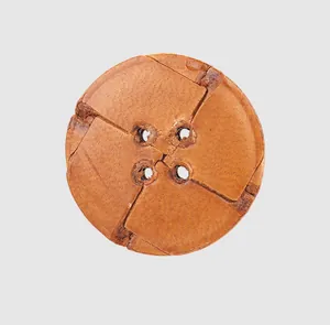 Close-up of premium brown leather button with four holes and cross carved pattern