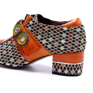 Nahaufnahme von Vintage-Leder-High-Heels mit Karomuster und dekorativen Blumenelementen