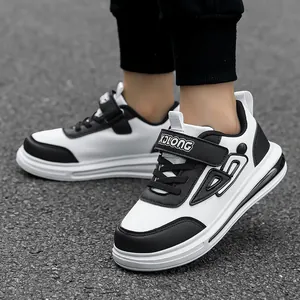 Classic black and white boys' casual sneakers with durable leather upper and velcro strap