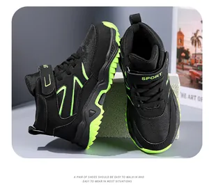 Detailed view of black and neon green boys' high-top outdoor hiking shoes with velcro