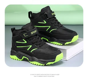 Macro view of black and lime green high-top children outdoor hiking and trekking shoes.