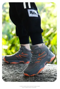 Side view of professional high-top kids outdoor hiking shoes on a rocky trail