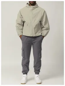 Close-up detail of a beige windproof hooded outdoor jacket with water-repellent fabric