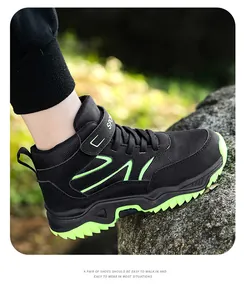 Close-up of boys black and neon green high-top outdoor hiking shoes on a rock