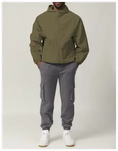 Full body view of model wearing an olive green hooded outdoor jacket and cargo pants.