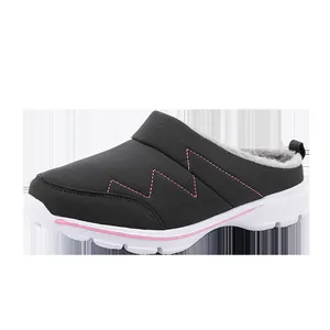 Black winter mule slippers featuring pink zigzag stitching and cozy grey faux fur lining