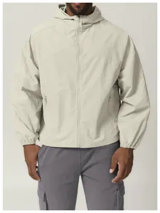 Close-up of a men's light beige windproof hooded jacket with front zipper detail