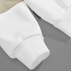 Macro-detail van de witte geribbelde manchetten en merklabel op een zwaar polo-sweatshirt