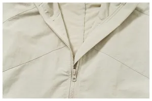 Close-up of smooth zipper and durable water-repellent fabric on beige outdoor jacket.